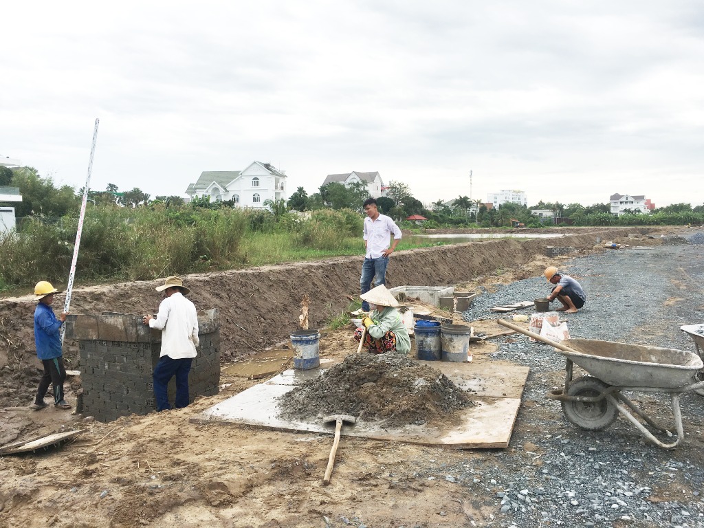 Đội ngũ kỹ sư trắc đạc cao độ và công nhân xây hố ga